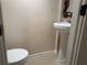 Decorated powder room with pedestal sink, updated toilet, and decorative mirror at 1570 Cedars Rd, Lawrenceville, GA 30045