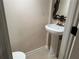 Decorated powder room with pedestal sink, updated toilet, and decorative mirror at 1570 Cedars Rd, Lawrenceville, GA 30045