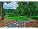 Landscaped backyard features a lush green lawn, mature trees, and a stone pathway at 3747 Sturbridge Ct, Tucker, GA 30084