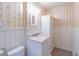 This bathroom has wallpapered walls, a tiled floor, a sink, and a toilet at 4077 Phils Ct, Tucker, GA 30084