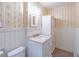 Traditional powder room with white wainscoting, floral wallpaper, and a white vanity with storage at 4077 Phils Ct, Tucker, GA 30084