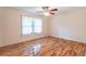 Bright bedroom featuring hardwood floors, a ceiling fan, and a large window at 4077 Phils Ct, Tucker, GA 30084