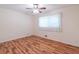 Cozy bedroom featuring hardwood floors, a ceiling fan, and a window with curtains at 4077 Phils Ct, Tucker, GA 30084