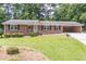 Charming brick home with an inviting entrance, a well-manicured lawn, and a convenient carport at 4077 Phils Ct, Tucker, GA 30084