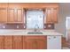 Kitchen area with light wooden cabinets, a sink under the window, and a white dishwasher at 4077 Phils Ct, Tucker, GA 30084