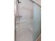 Easy access walk-in tiled shower features a frosted glass door and hand rails at 4077 Phils Ct, Tucker, GA 30084