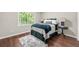 Cozy bedroom featuring a plush rug, hardwood floors, neutral colors, and great natural lighting at 4555 Holliston Rd, Dunwoody, GA 30360
