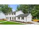 Spacious two-story home with white brick, dark shutters, and a neatly landscaped yard and an attached garage at 4555 Holliston Rd, Dunwoody, GA 30360