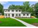 Charming two-story home with white brick, dark shutters, and a well-manicured lawn at 4555 Holliston Rd, Dunwoody, GA 30360
