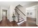 Welcoming foyer with hardwood floors, stylish staircase, and an elegant plant display on a table at 4555 Holliston Rd, Dunwoody, GA 30360