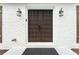 Attractive double front door with decorative pattern, flanked by sconces and wooden shutters at 4555 Holliston Rd, Dunwoody, GA 30360