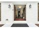 Inviting front entrance with double doors, white brick, and classic lantern sconces highlighting the entry at 4555 Holliston Rd, Dunwoody, GA 30360