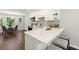 Modern kitchen boasts white cabinetry, granite countertops, breakfast bar, and adjacent dining area at 4555 Holliston Rd, Dunwoody, GA 30360