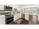 Bright kitchen with stainless steel appliances, white cabinets, and a view into the dining area at 4555 Holliston Rd, Dunwoody, GA 30360