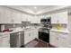 Bright kitchen featuring white cabinetry, stainless steel appliances, and modern countertops at 4555 Holliston Rd, Dunwoody, GA 30360