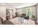 Bright living room with hardwood floors, two windows, and comfortable seating arrangement with plants at 4555 Holliston Rd, Dunwoody, GA 30360
