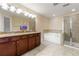 This bathroom includes a double vanity with granite countertop, garden tub and shower with glass enclosure at 8295 Village Pl, Suwanee, GA 30024