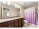 Bathroom featuring double vanity, granite countertop, large mirror, and a shower with colorful curtain at 8295 Village Pl, Suwanee, GA 30024
