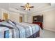 Large main bedroom featuring a tray ceiling, fan, neutral walls, and a flatscreen TV at 8295 Village Pl, Suwanee, GA 30024
