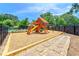Community playground with a slide and swings and bordered by stone pavers at 8295 Village Pl, Suwanee, GA 30024