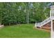 Expansive backyard with lush lawn and stairs leading up to a spacious deck at 1140 River Laurel Dr, Suwanee, GA 30024