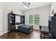 Modern bedroom with dark wood floors, a bed with built-in shelving, and a bright window at 1140 River Laurel Dr, Suwanee, GA 30024