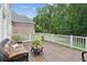 Relaxing outdoor deck with wicker furniture and views of the lush, wooded backyard at 1140 River Laurel Dr, Suwanee, GA 30024