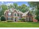 Elegant brick home with a lush green lawn and manicured landscaping at 1140 River Laurel Dr, Suwanee, GA 30024