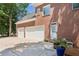 Brick home showcasing a three car garage, large driveway, and manicured landscaping at 1140 River Laurel Dr, Suwanee, GA 30024