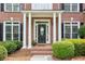 Inviting front entry with white columns, brickwork, and meticulously kept greenery at 1140 River Laurel Dr, Suwanee, GA 30024