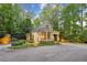Well-lit, charming guard house at the gated entrance, surrounded by trees and manicured landscaping at 1140 River Laurel Dr, Suwanee, GA 30024