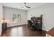 Bright home office featuring dark wood floors, a ceiling fan, and a large window for natural light at 1140 River Laurel Dr, Suwanee, GA 30024