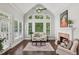 Comfortable living room with large windows, a fireplace, hardwood floors, and bright natural light at 1140 River Laurel Dr, Suwanee, GA 30024