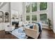 Elegant living room with a fireplace, large windows, and comfortable seating at 1140 River Laurel Dr, Suwanee, GA 30024