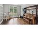 Sunlit room with a piano, hardwood floors, and natural light creating a perfect space for music at 1140 River Laurel Dr, Suwanee, GA 30024