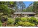 Beautiful backyard featuring a stone patio, dining set, and lush landscaping at 2221 Fairoaks Rd, Decatur, GA 30033
