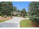 Spacious concrete driveway leading to a brick home surrounded by mature trees and manicured landscaping at 2221 Fairoaks Rd, Decatur, GA 30033
