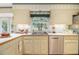 A kitchen featuring cream cabinets, tile flooring, and a stainless steel dishwasher at 2221 Fairoaks Rd, Decatur, GA 30033