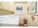 Laundry room with upper cabinets, patterned wallpaper, and a washing machine and dryer at 2221 Fairoaks Rd, Decatur, GA 30033