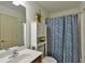 Well-lit bathroom showcasing a vanity with a sink, cabinet, and a shower with a decorative blue patterned curtain at 4241 Hampton Mill Pkwy, Douglasville, GA 30135
