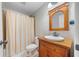 Bathroom featuring a single sink, vanity, toilet, shower with curtain, and tile flooring at 5585 Lavender Farms Rd, Powder Springs, GA 30127