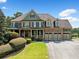 Charming home with stone accents, three-car garage, covered porch and manicured lawn at 5585 Lavender Farms Rd, Powder Springs, GA 30127