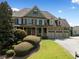 Beautiful front exterior with a manicured lawn and mature landscaping on a sunny day at 5585 Lavender Farms Rd, Powder Springs, GA 30127