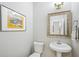 Stylish half bathroom features a modern sink, elegant mirror, and decorative artwork at 7710 Bucknell Terrace, Fairburn, GA 30213