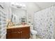 Well-lit bathroom featuring a large mirror and floral shower curtain at 7710 Bucknell Terrace, Fairburn, GA 30213