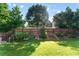 Fenced backyard with green grass, landscaping and a retaining wall at 2481 Southhaven Ln, Buford, GA 30519