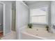 Bright bathroom featuring a soaking tub, shower, and large window at 2481 Southhaven Ln, Buford, GA 30519