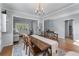 Open-concept dining area with a hardwood table, view into living room, and natural light at 2481 Southhaven Ln, Buford, GA 30519