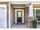 Close-up of a home's stone-accented front entrance with a dark wooden door and sidelight window at 2481 Southhaven Ln, Buford, GA 30519