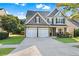 Charming two-story home with a two-car garage, manicured lawn, and stone and siding facade at 2481 Southhaven Ln, Buford, GA 30519